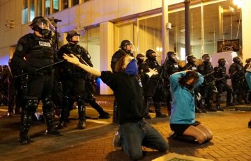 Demonstrators gesture in front of the police during a protest against the election of Republican Donald Trump as President of the United States in Portland, Oregon