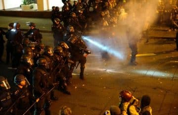 A police officer sprays the crowd with an irritant during a protest against the election of Republican Donald Trump as President of the United States in Portland, Oregon